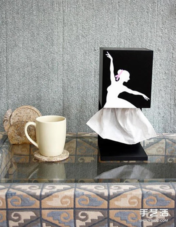 The elegant ballerina draws the paper out of the paper box and feels artistic when she holds it