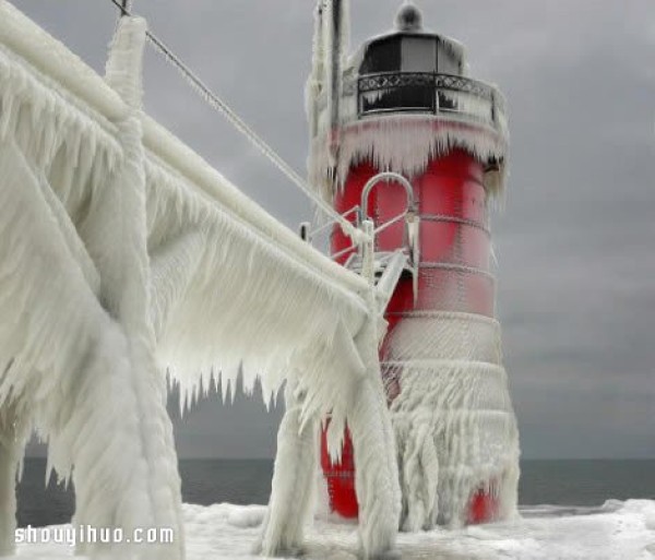 The spectacular lighthouse scene on the edge of Lake Michigan under the snowstorm and cold wave