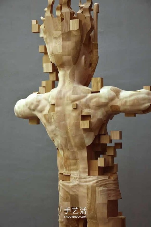 The wooden man is pixelated! The combination of traditional wood carving and digital elements