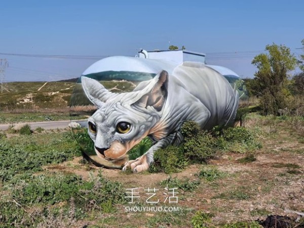 A street artist uses spray paint to transform a petrol tank into a sphinx cat