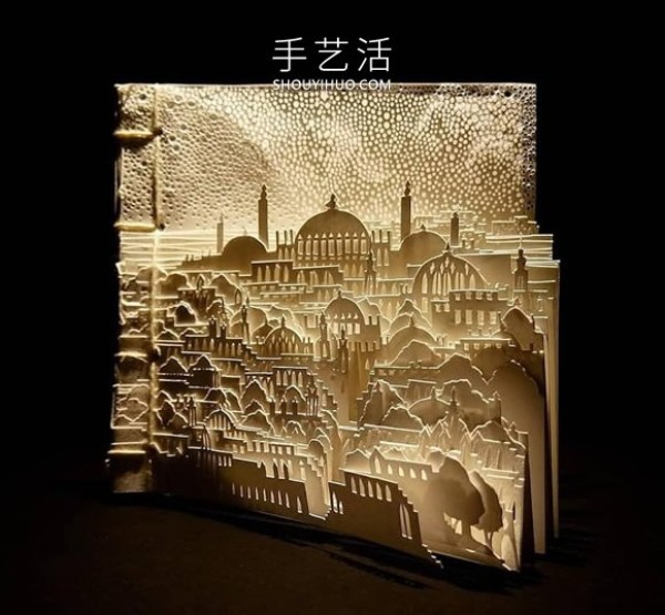 A three-dimensional paper sculpture of a city and forest made from dozens of sheets of paper