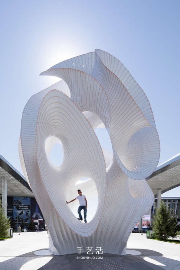 Two centimeter thin aluminum sheets are interspersed and stacked to create a 13-meter-high white tower