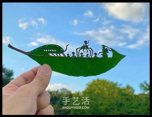 The artist carefully carves the complex scenes on the leaves