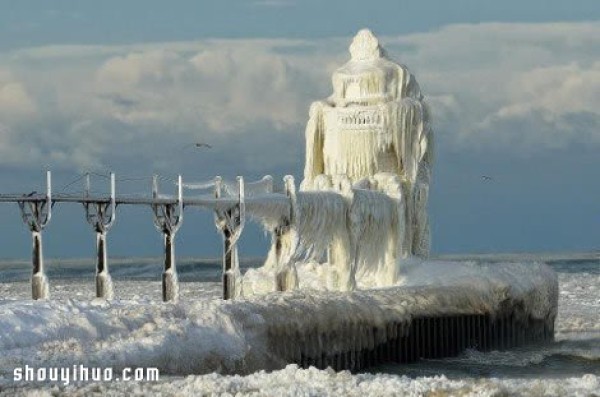 The spectacular lighthouse scene on the edge of Lake Michigan under the snowstorm and cold wave