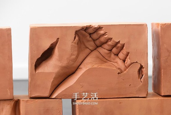 The warmth left by my father! Plaster sculpture of hands in red bricks