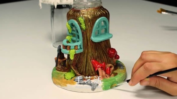 Handmade fairy house with paper clay and glass bottles