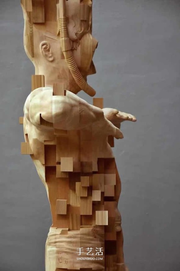 The wooden man is pixelated! The combination of traditional wood carving and digital elements