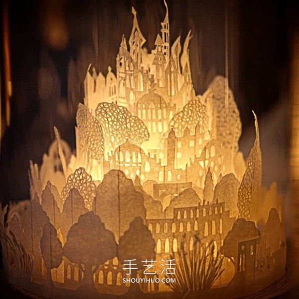 A three-dimensional paper sculpture of a city and forest made from dozens of sheets of paper