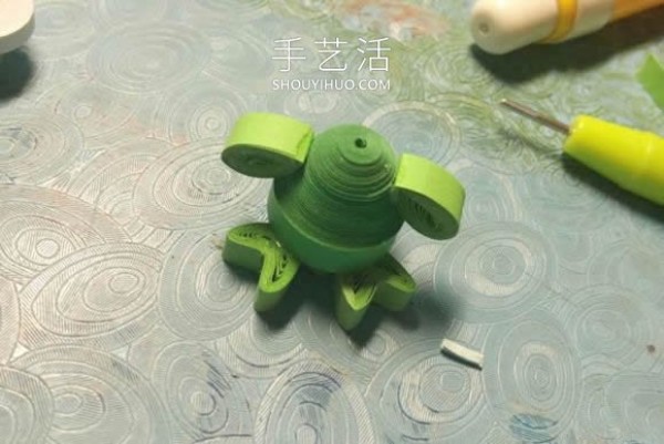 Simple tutorial on making a small green frog from quilled paper