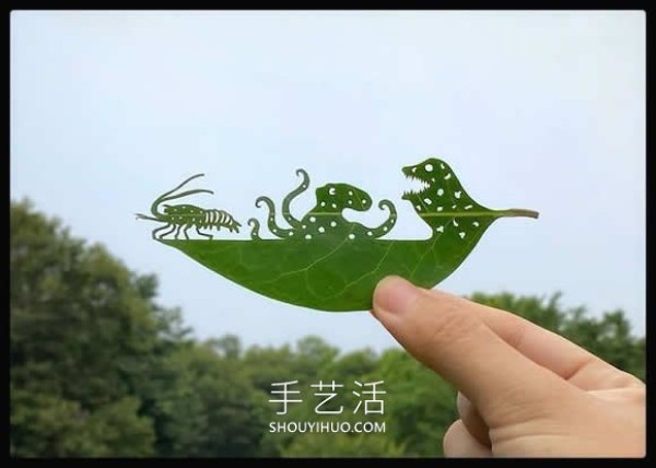 The artist carefully carves the complex scenes on the leaves