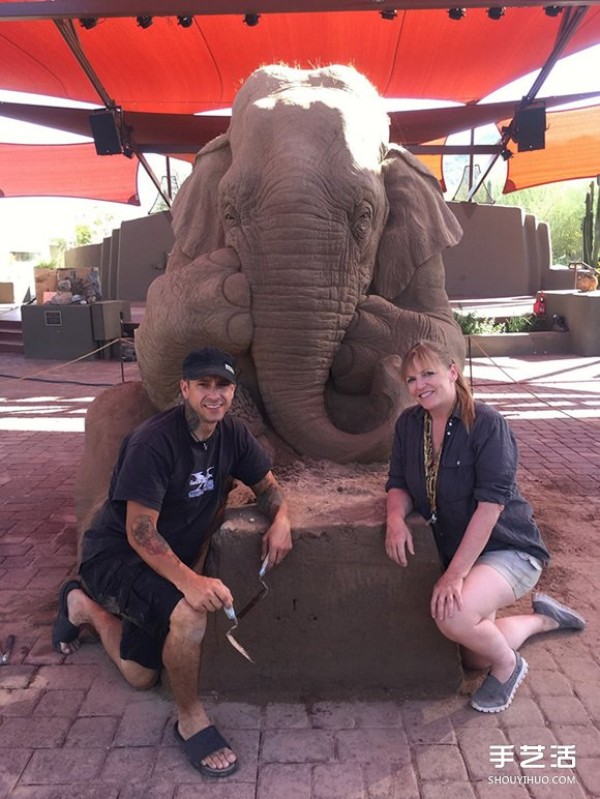 A lifelike sand sculpture in the shape of an elephant and a mouse playing chess, full of a fairy tale atmosphere