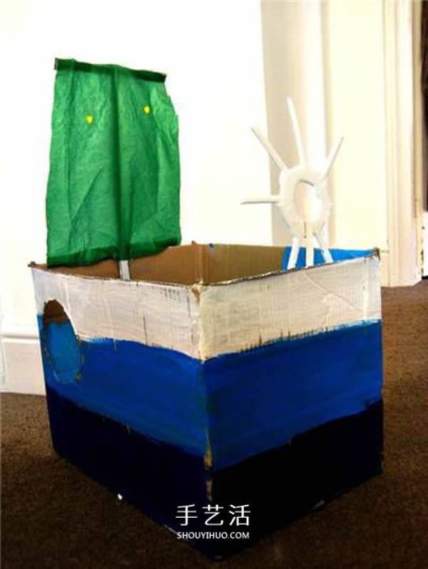 Simple cardboard boxes are used to make a toy boat with sails by hand