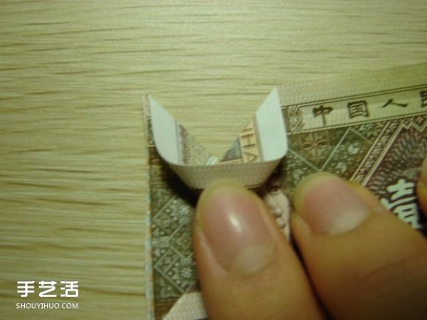 Paper money origami camera illustration and a detailed explanation of how to fold a dollar bill into a camera