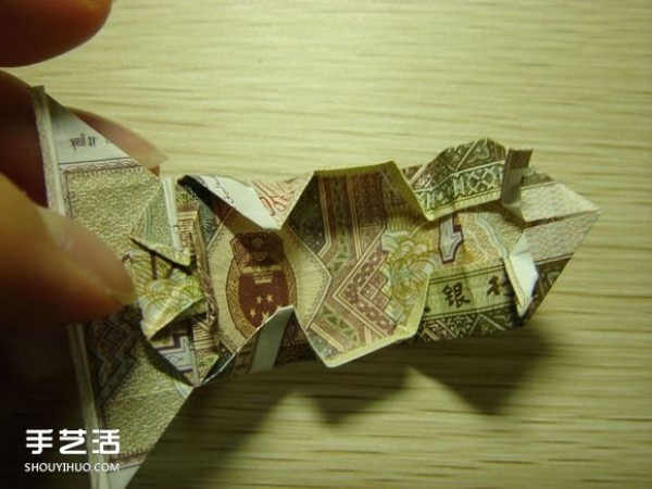 Paper money origami camera illustration and a detailed explanation of how to fold a dollar bill into a camera