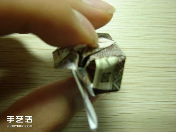 Paper money origami camera illustration and a detailed explanation of how to fold a dollar bill into a camera