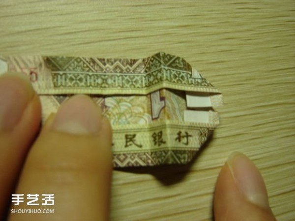 Paper money origami camera illustration and a detailed explanation of how to fold a dollar bill into a camera