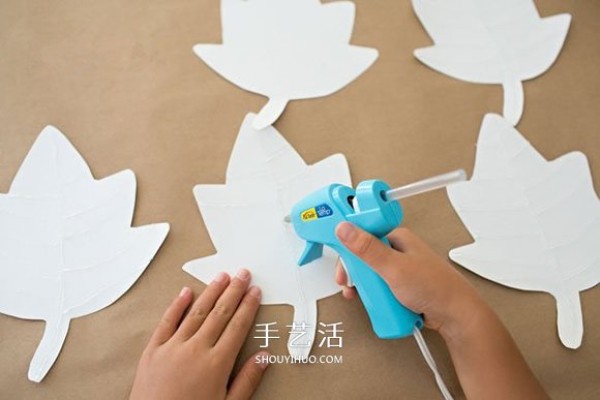 Illustration of how children make handmade New Year hangings from cardboard and maple leaf hangings