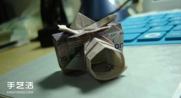 Paper money origami camera illustration and a detailed explanation of how to fold a dollar bill into a camera