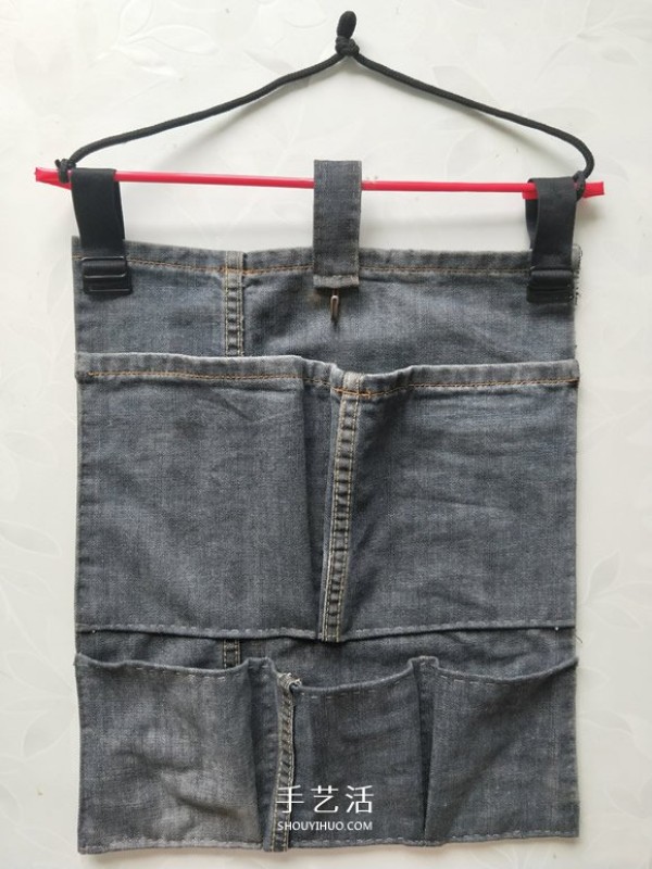 Illustration of a DIY method to make a wall-mounted storage bag from waste jeans