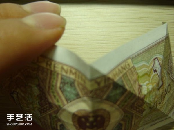 Paper money origami camera illustration and a detailed explanation of how to fold a dollar bill into a camera