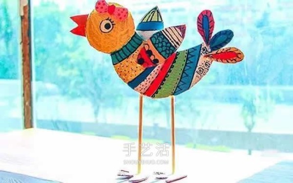 Kindergarten cardboard waste is used to make a colorful bird by hand