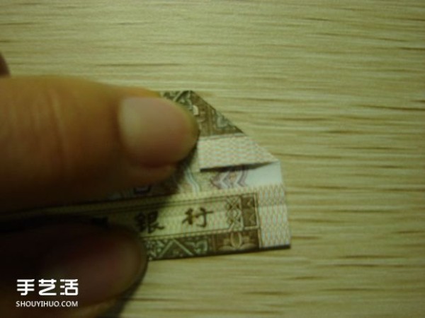 Paper money origami camera illustration and a detailed explanation of how to fold a dollar bill into a camera