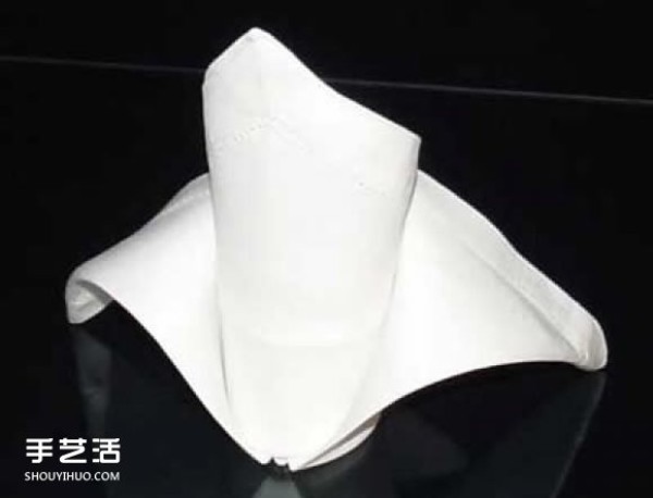 An illustration of how to fold a napkin to create a three-dimensional crown