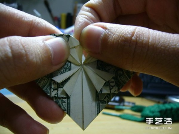 Illustration of the origami method of folding a dollar heart into a dollar bill