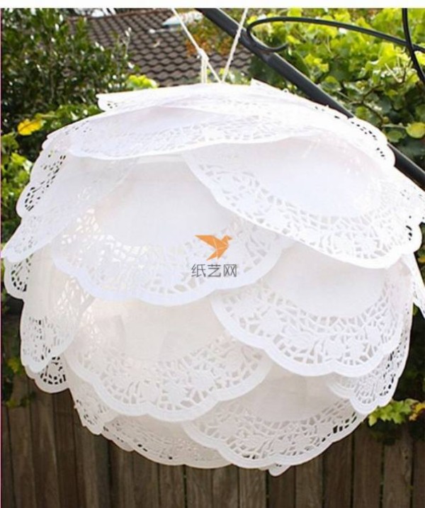 A beautiful lantern made of paper art hollow lace dessert paper mat