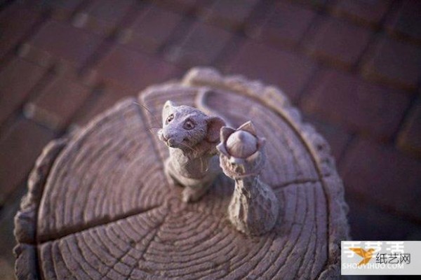 A sand sculpture in the shape of an elephant and mouse playing chess that looks lifelike and full of fairy tale atmosphere