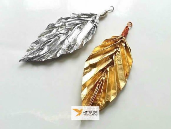 Children use tinfoil to fold paper leaf pendants