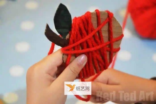 Kindergarten children learn to make apples using cardboard and wool