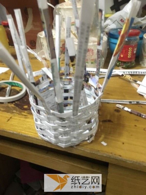 Illustrated tutorial on turning waste into treasure by weaving newspapers and magazines into a small basket