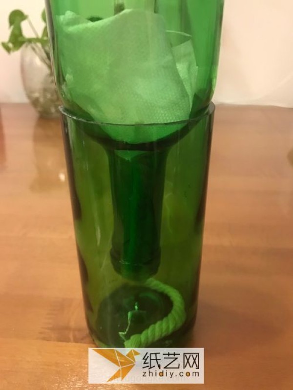 A small fresh vase made from discarded wine bottles.