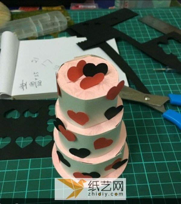 Handmade three-dimensional paper art cakes are made using the method of exploding box mechanisms