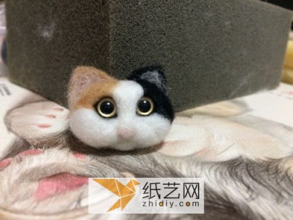 A beautiful little cat head made of wool felt. Complete illustrated tutorial of handmade wool felt.