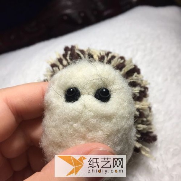 Happy little hedgehog doll made from wool felt and yarn balls