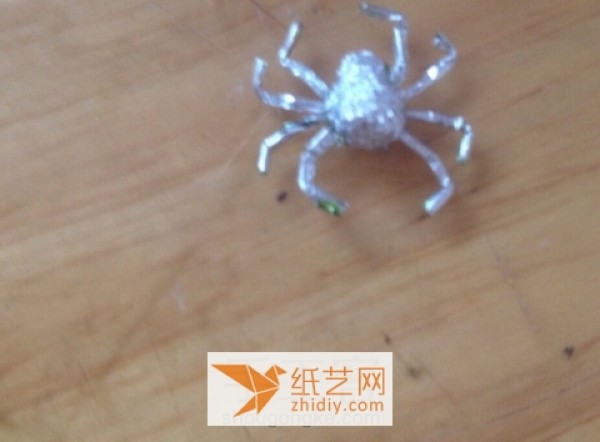 Illustrated tutorial on how to make a Halloween spider by turning gum wrappers into treasures