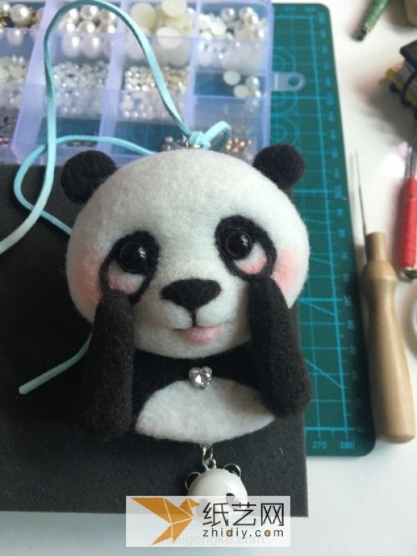 Tutorial on how to make a red panda making a wool felt car ornament, a fun Mother’s Day gift