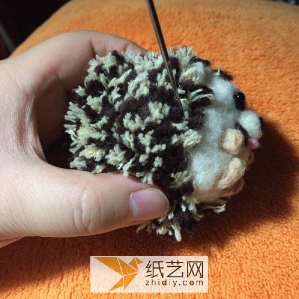 Happy little hedgehog doll made from wool felt and yarn balls