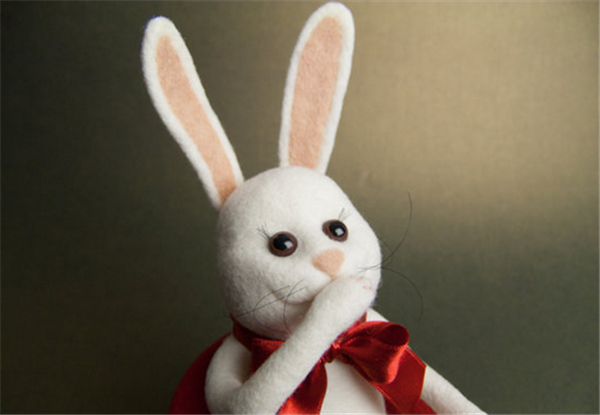 A playful and cute Mr. Rabbit holding a carrot made by DIY using handmade wool felt