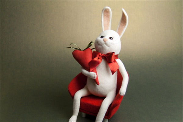 A playful and cute Mr. Rabbit holding a carrot made by DIY using handmade wool felt