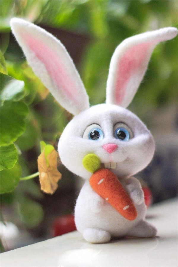 Cute cute handmade wool felt white rabbit holding a carrot