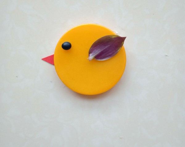 Illustration of how to make a DIY bird using bottle caps and leaves