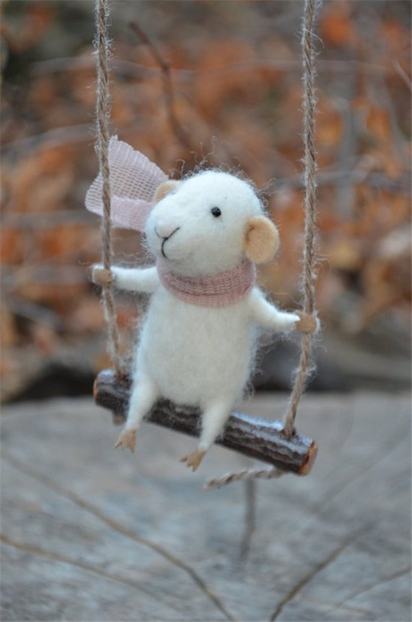 A creative work of a cute little mouse who loves reading made from handmade wool felt DIY