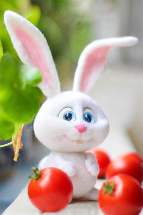 Cute cute handmade wool felt white rabbit holding a carrot