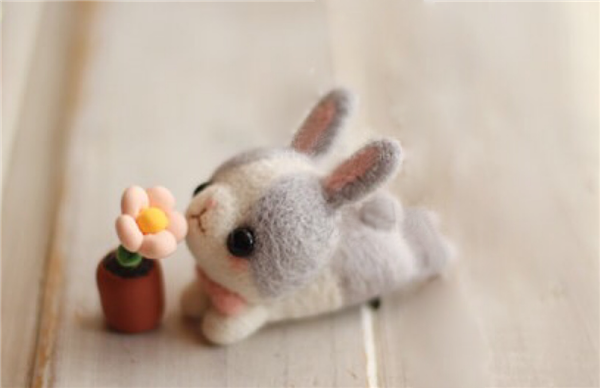 Cute and adorable handmade wool felt DIY production of little gray rabbits and flowers