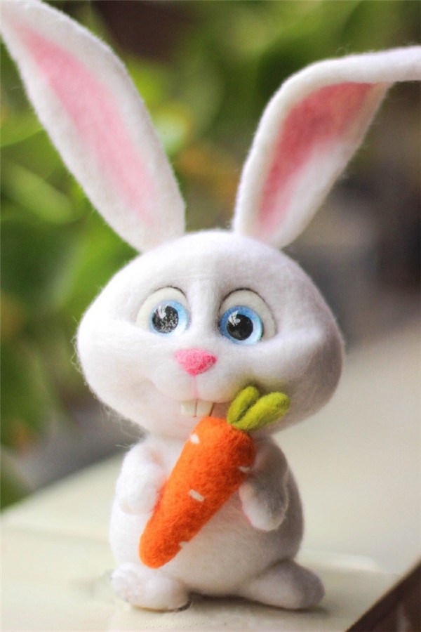 Cute cute handmade wool felt white rabbit holding a carrot