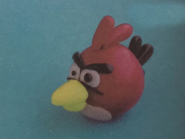 The process of making a simple colored clay cardinal for children