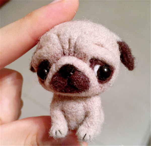 DIY pug made from wool felt with a disgusted look on his face